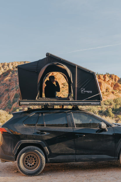 Intrepid Geo 2.0 open on a RAV4 roof rack in red rock country, someone sitting inside