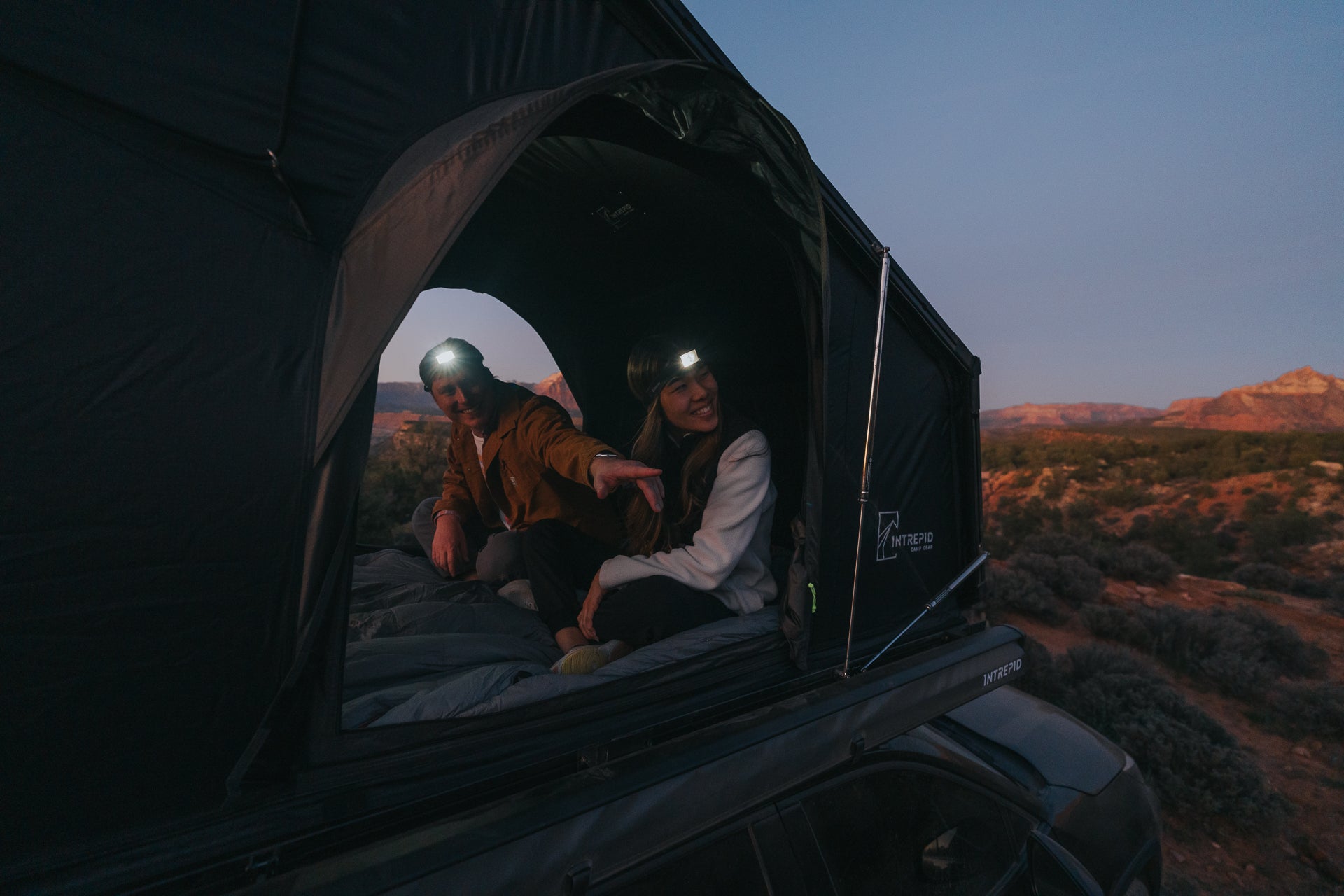 Two people inside the Intrepid Geo 2.0 at dusk, headlamps on