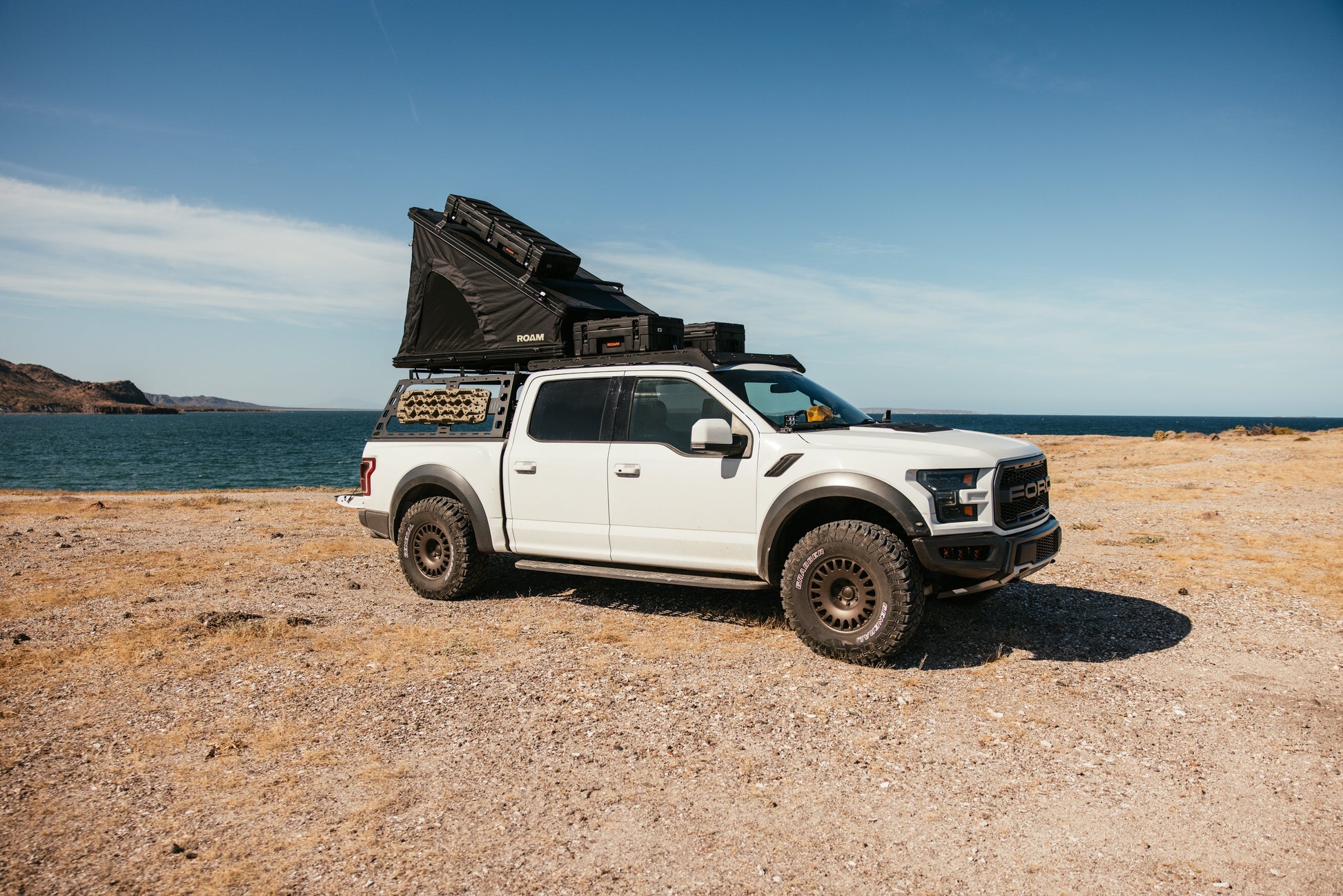 ROAM Desperado open on a Ford Raptor, seen from the side on a beach