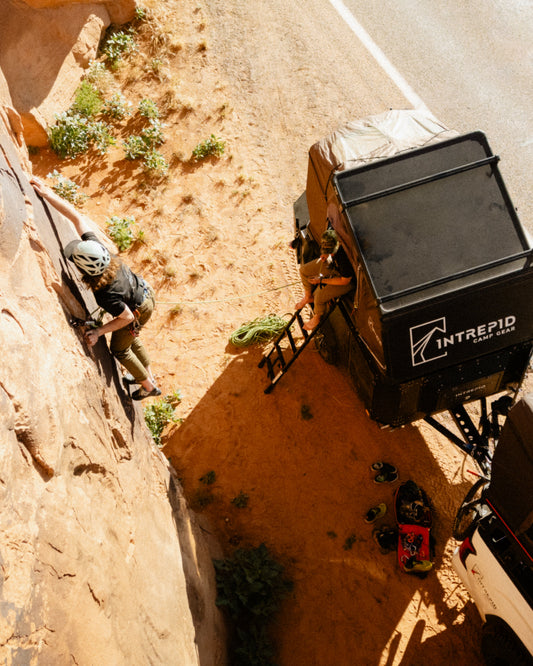 Intrepid Geo 3.0 Pro open on a truck below a sandstone wall, with a climber on the route above