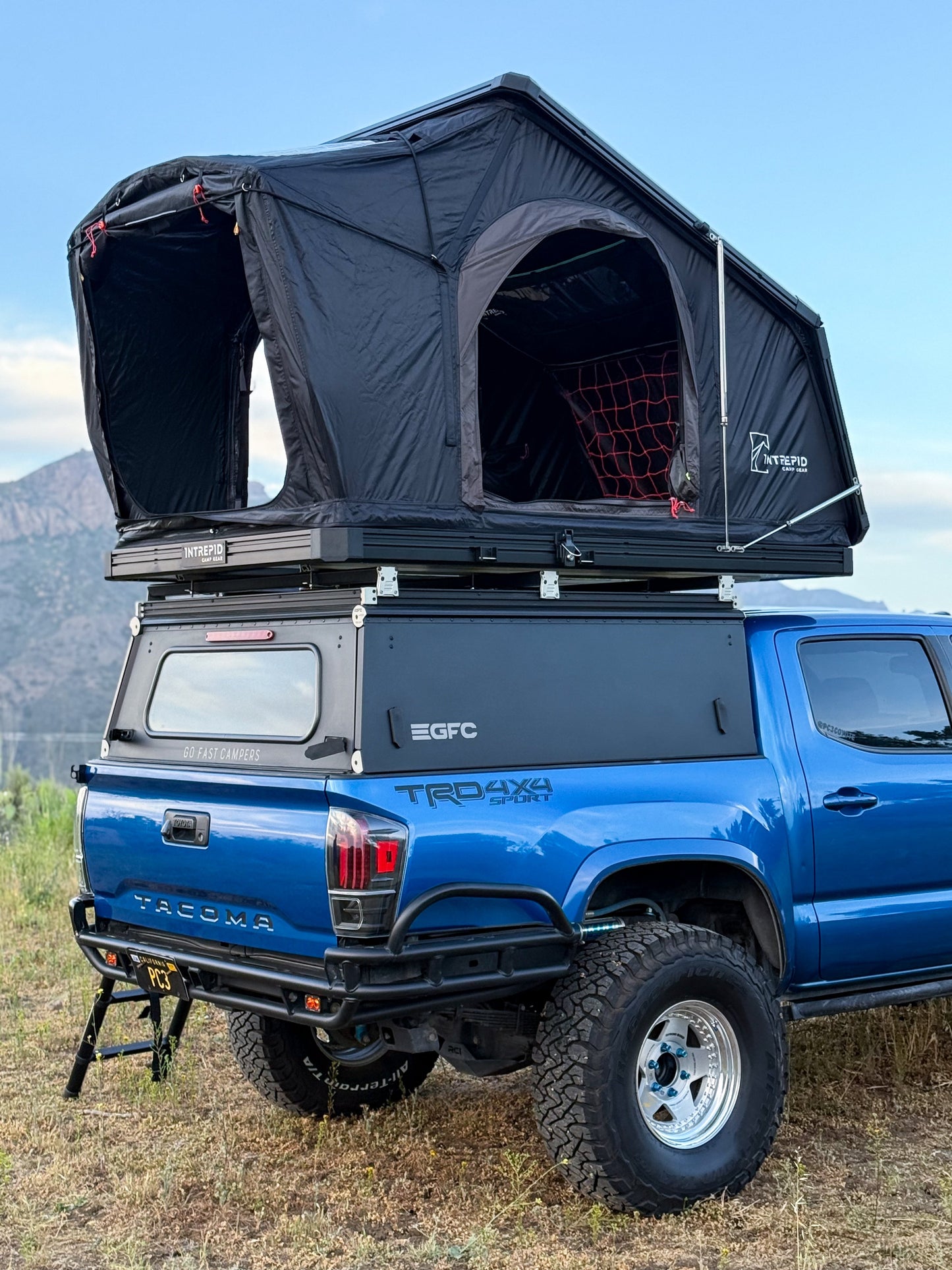 Intrepid Geo 2.5 open on a blue Tacoma with a canopy, both doors unzipped