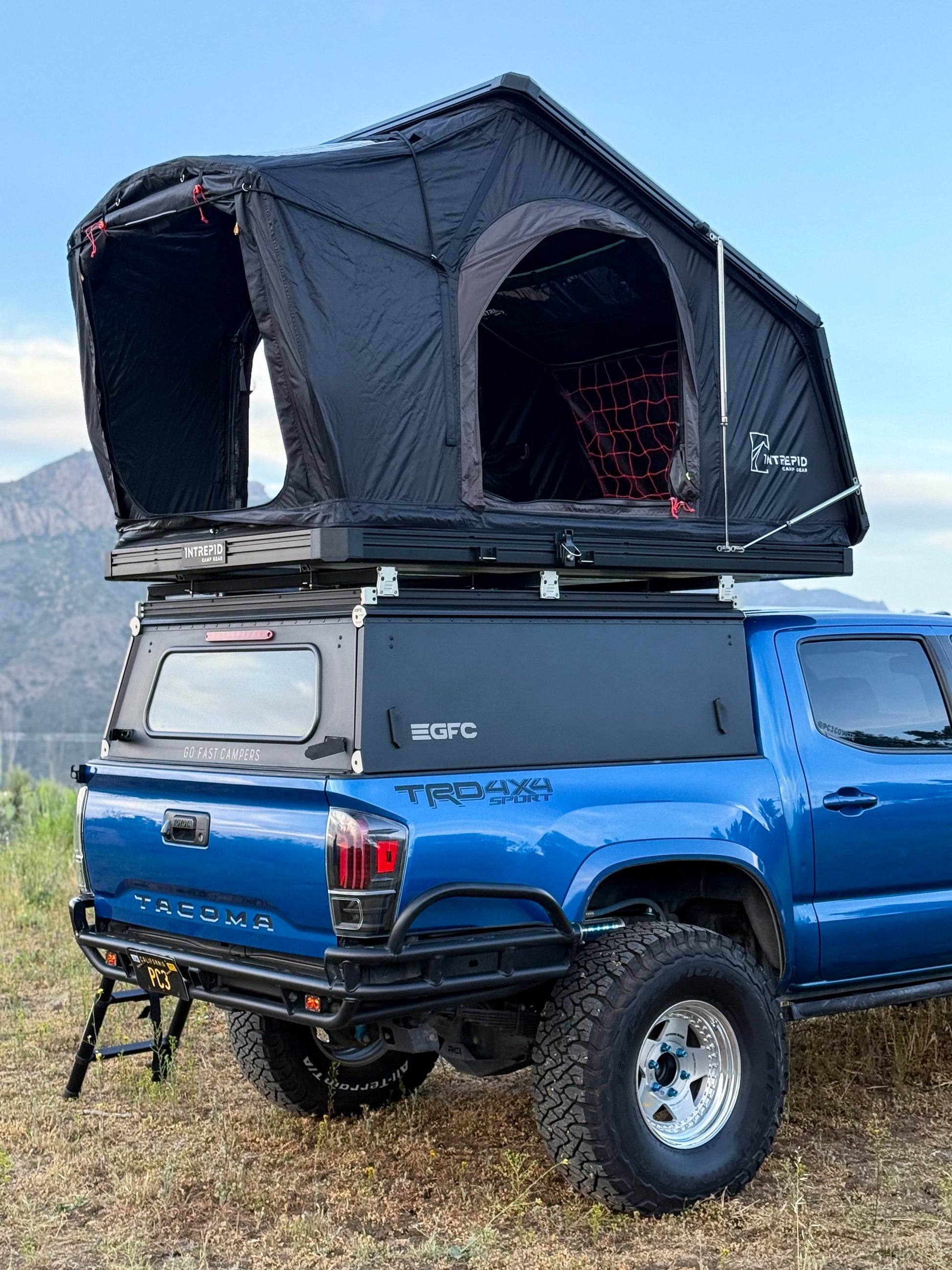 Intrepid Geo 2.5 open on a blue Tacoma with a canopy, both doors unzipped
