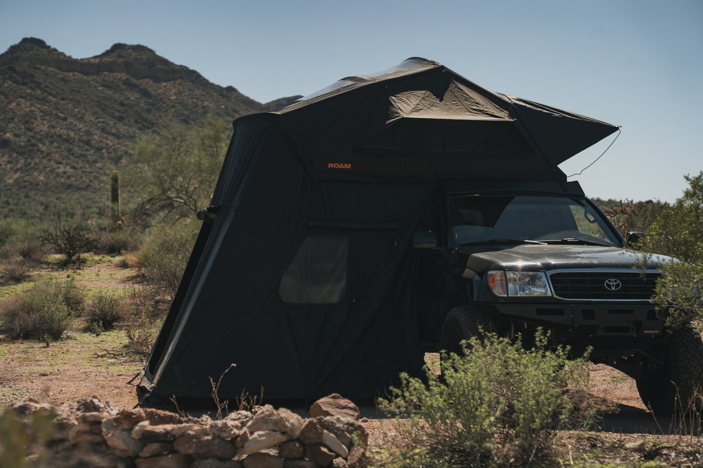 ROAM Vagabond XL 2.0 in Black with the annex fitted, alongside a Land Cruiser